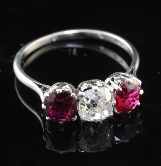 An early 20th century platinum and three stone ruby and diamond ring, size Q.